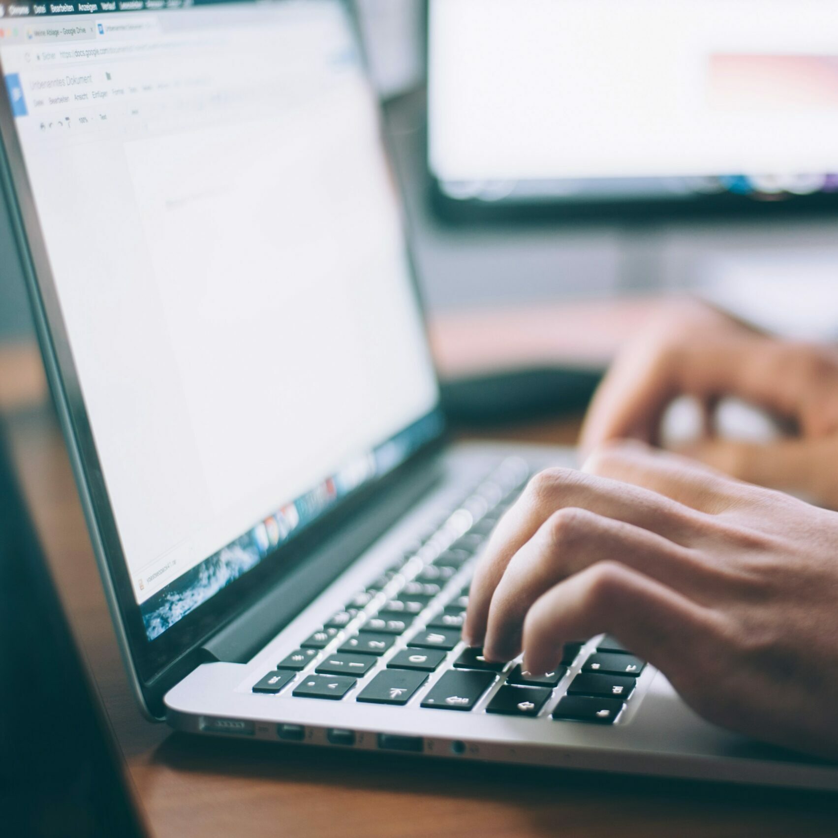 hands typing on the keyboard of a laptop